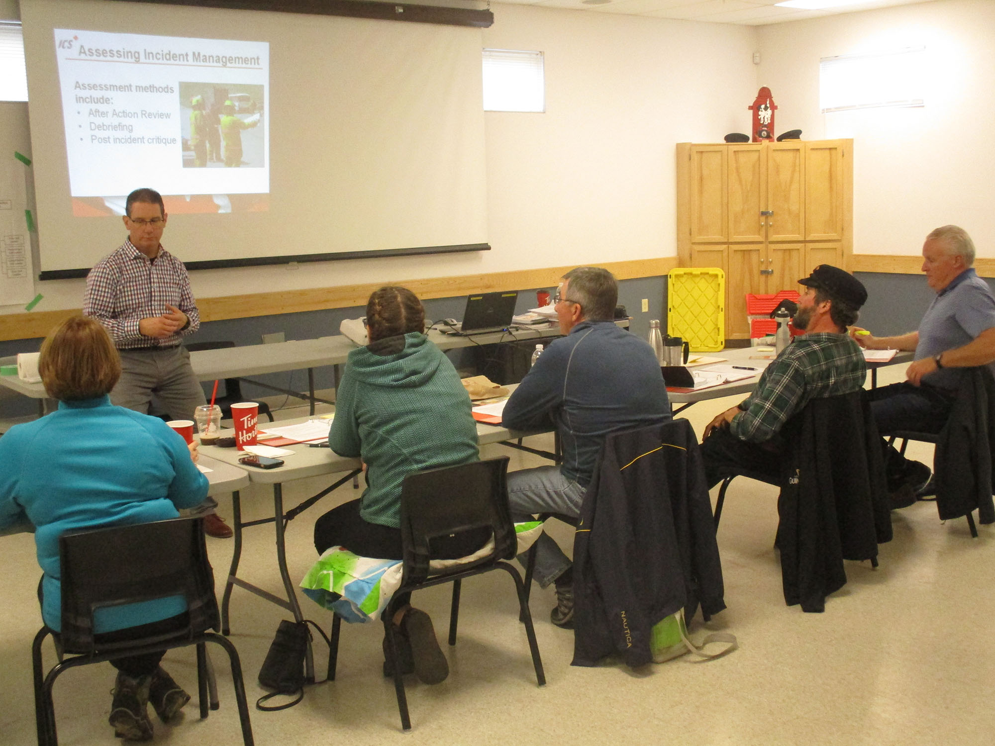 Person stands in front of a classroom type setting training new volunteers.