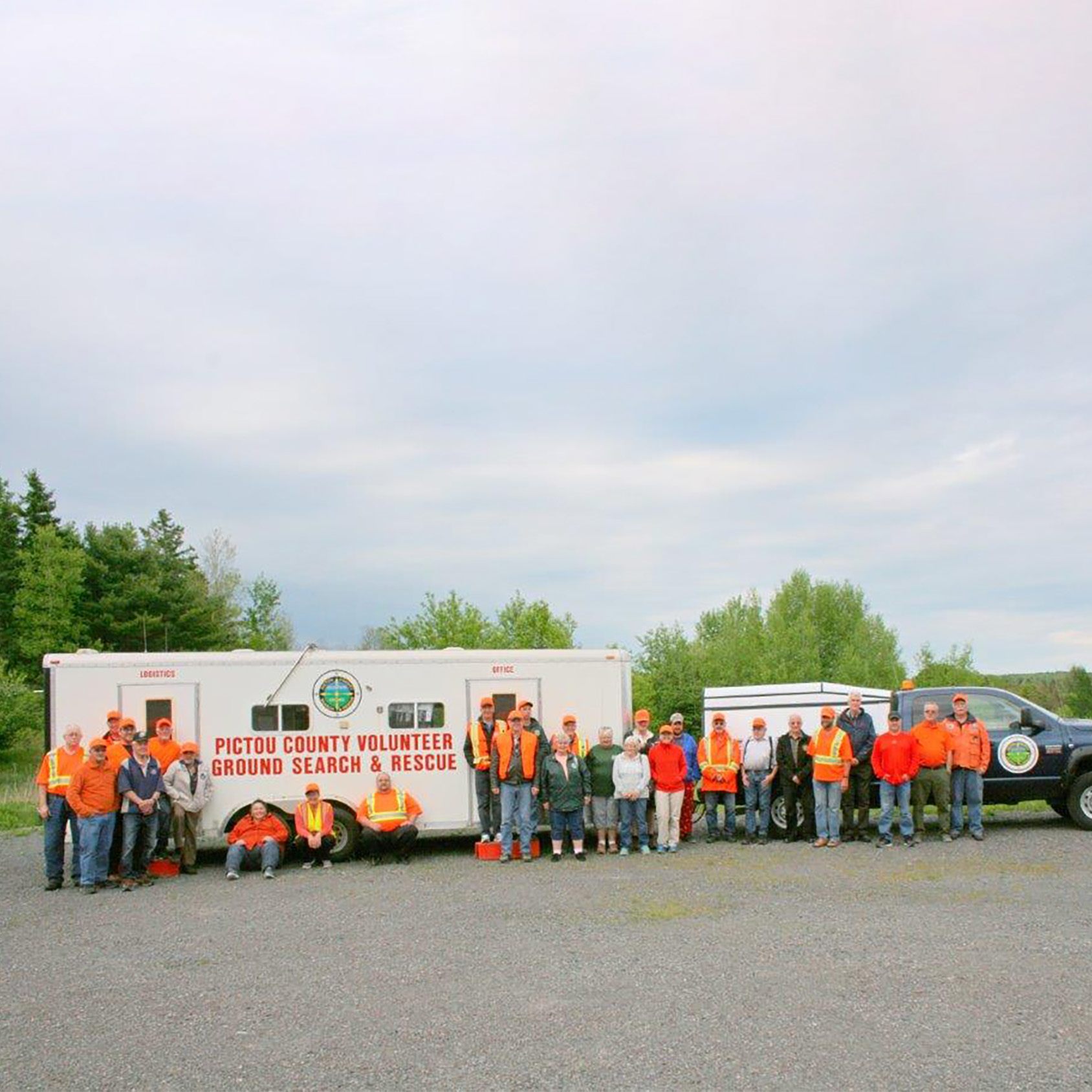 An older photo of the entire Volunteer Team standing in front of the mobile command post.